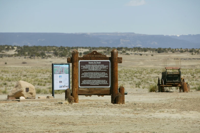 a sign in front of an old car near a monument