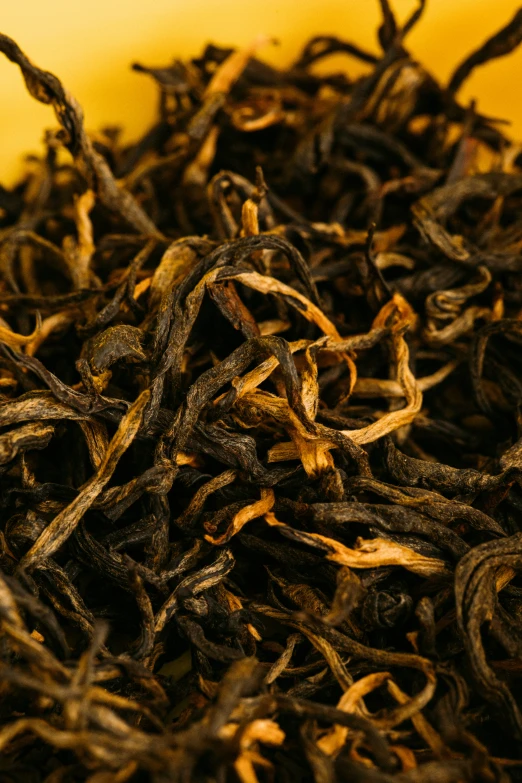 a pile of dark yellow tea with brown flecks