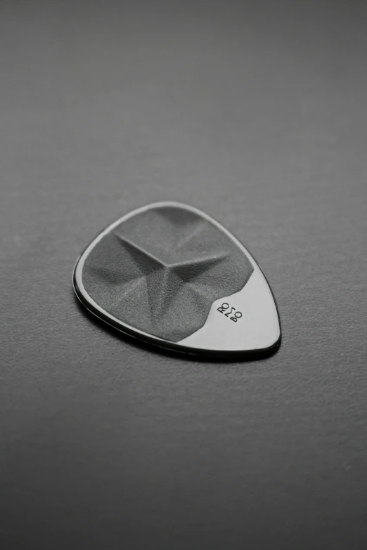 a guitar picker resting on a black surface