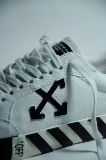 a pair of white converse style shoes with arrows on them