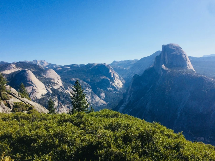 the beautiful mountains with trees and greenery look out to a clear blue sky