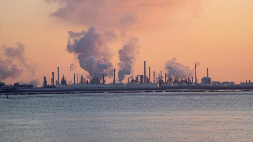 the skyline shows factories and boats in the water