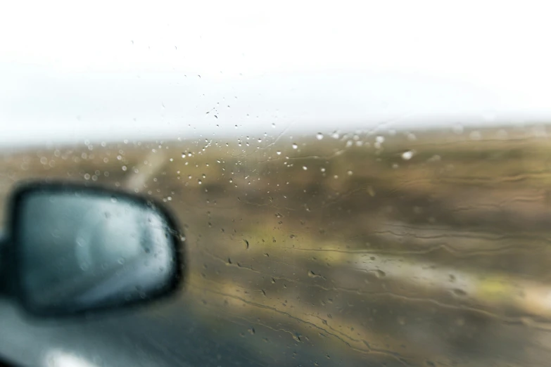 the view of a dirt and grass land through a car window