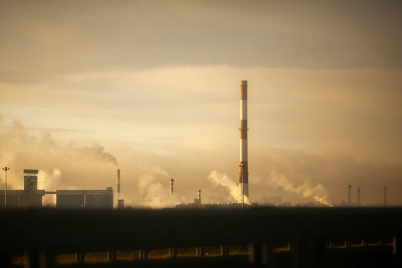 smoke is billowing out from the stacks of industrial buildings