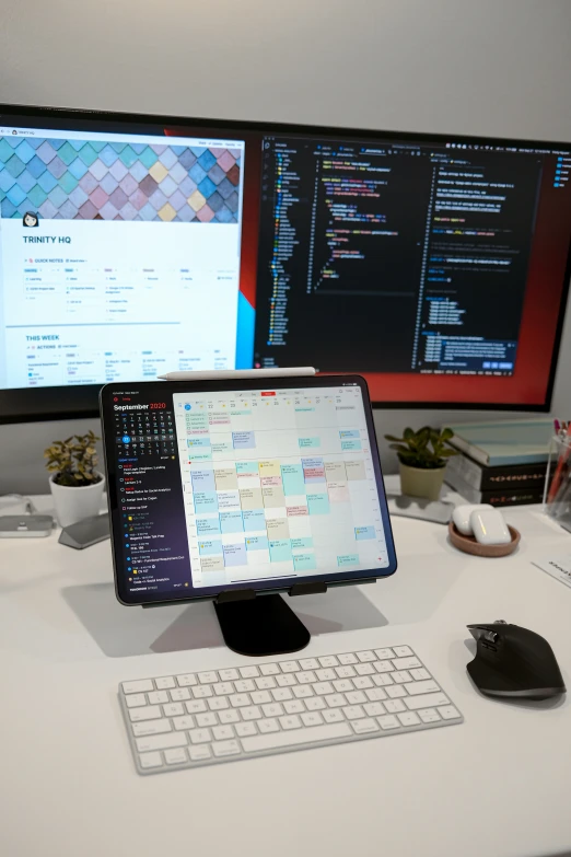 a small keyboard and mouse in front of two large screens