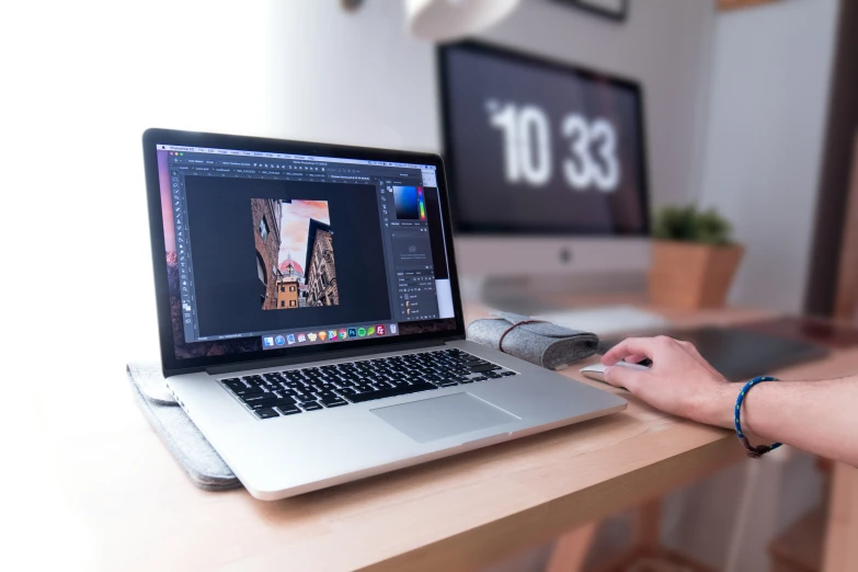 a laptop and monitor on a table with a computer screen