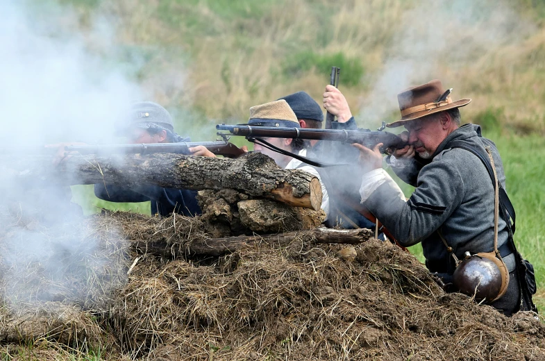 men wearing hats, holding guns and smoking soing