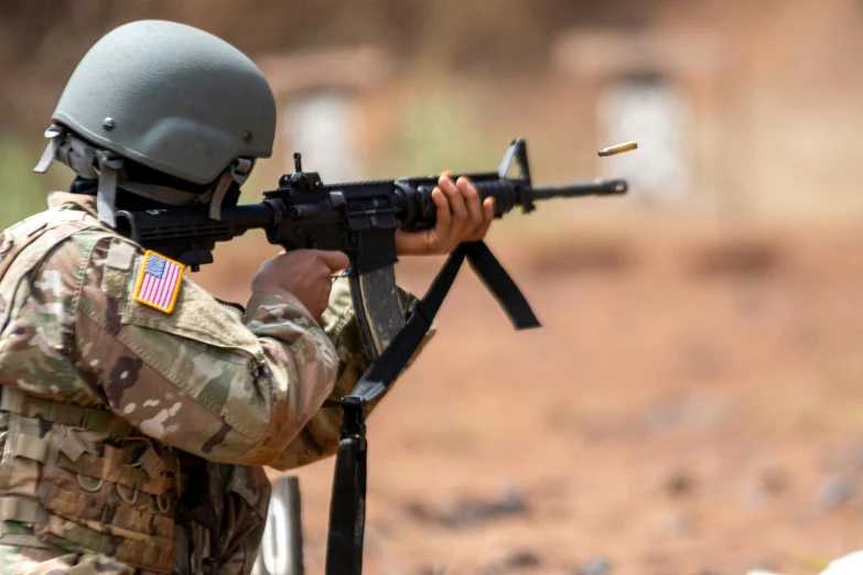 an armed man in camouflage shooting a rifle