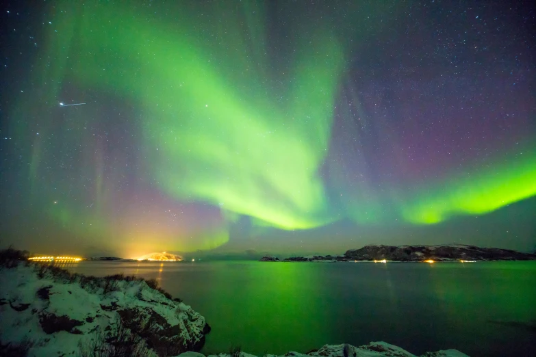 the aurora lights are shining above the water