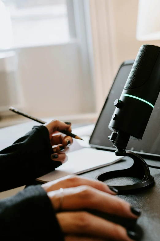 someone using a laptop and a camera with a lens next to it