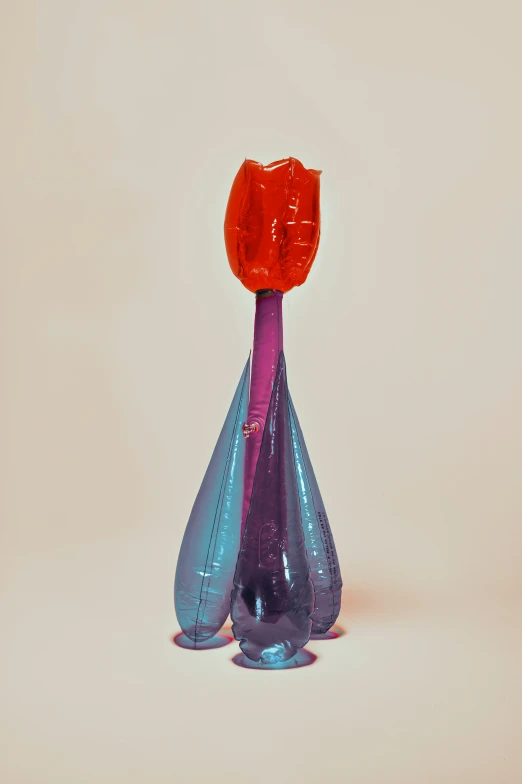 two plastic vases one with a red flower sitting on top
