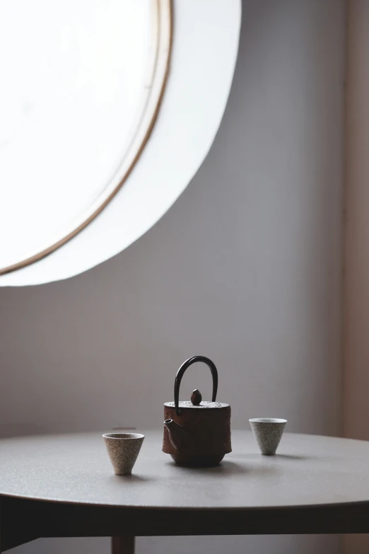 a tea set sitting on top of a table in front of a giant clock