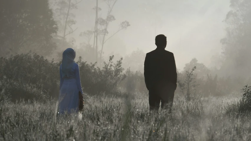 the image of a man and a woman in a field is very surreal