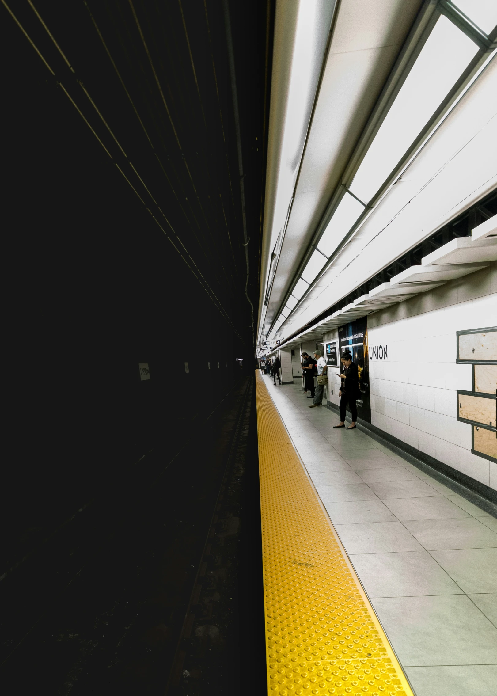 a subway station with people getting on and off the platform