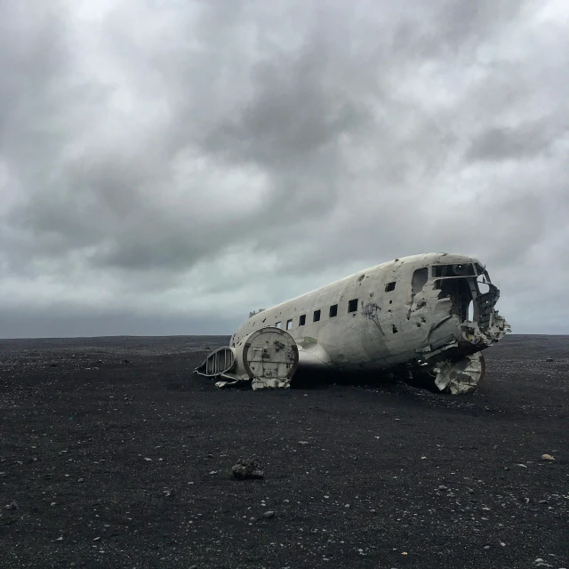 the airplane is abandoned on the ground on a cloudy day