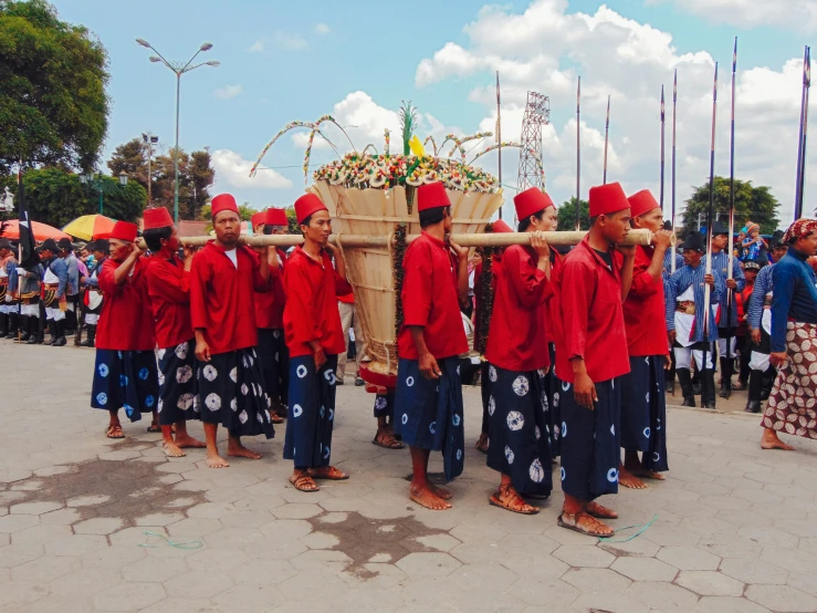 a group of people in red shirts standing in front of an animal