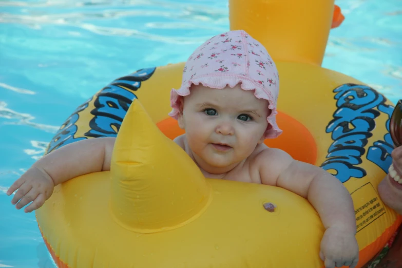 an adorable baby sitting in an orange raft