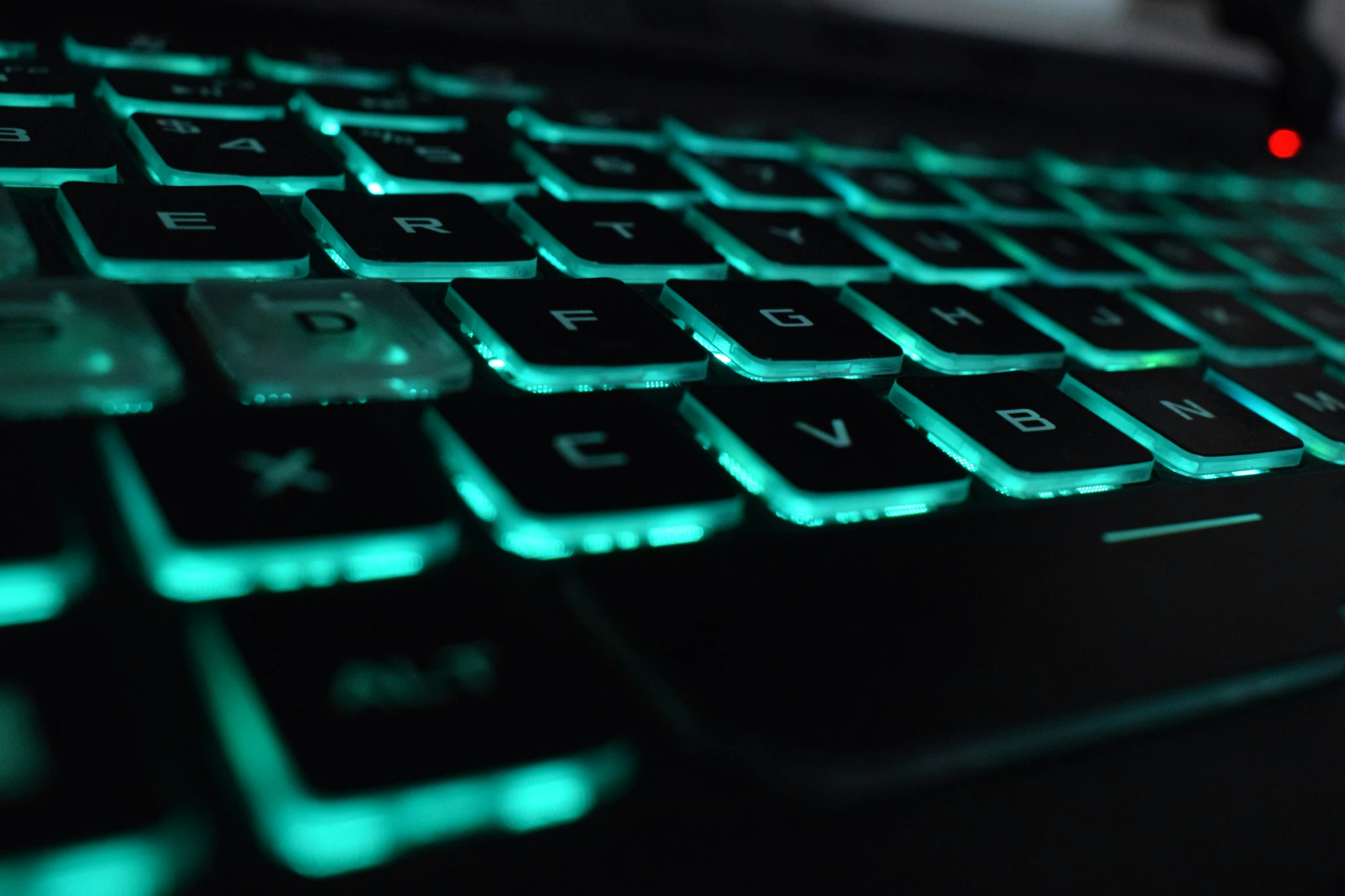 a close up of a keyboard with green lighting on it