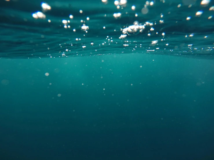 some white bubbles in blue water with a sky background