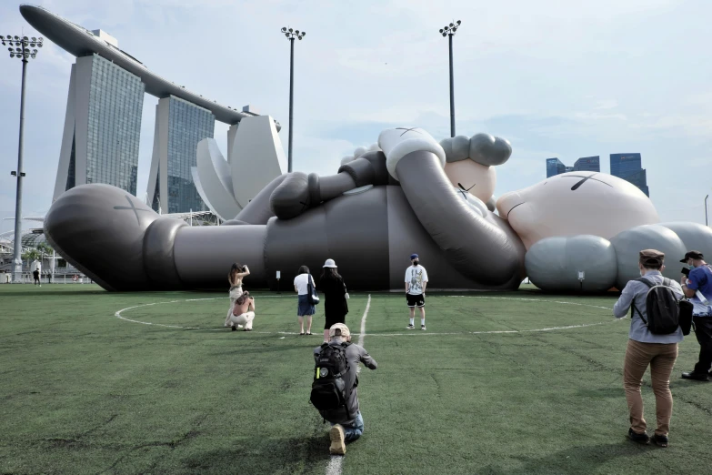 people standing around the inflatable soccer ball on the field