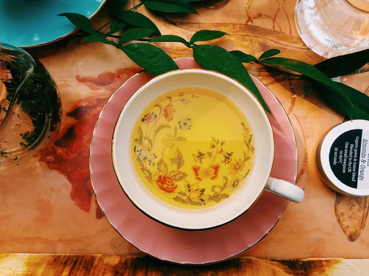 a cup of yellow tea on top of a table