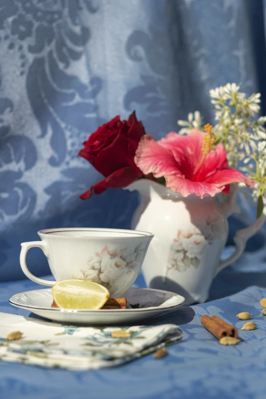 a teacup and saucer with some fruit and flowers on it