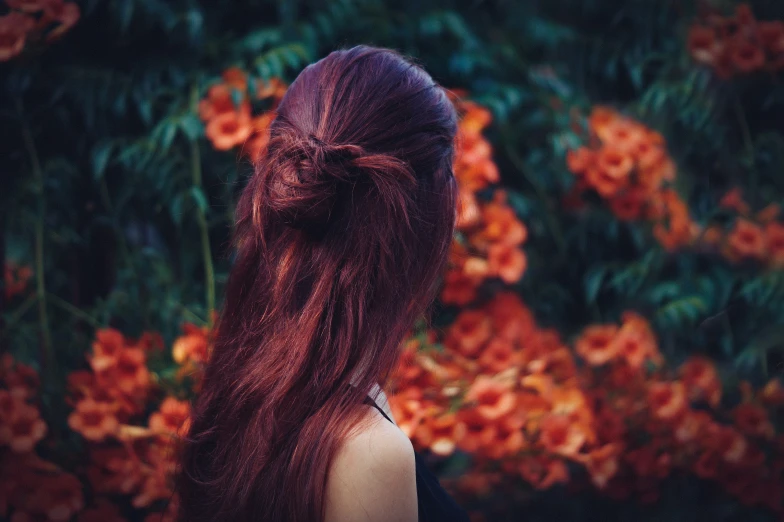 girl with long red hair looking away from the camera