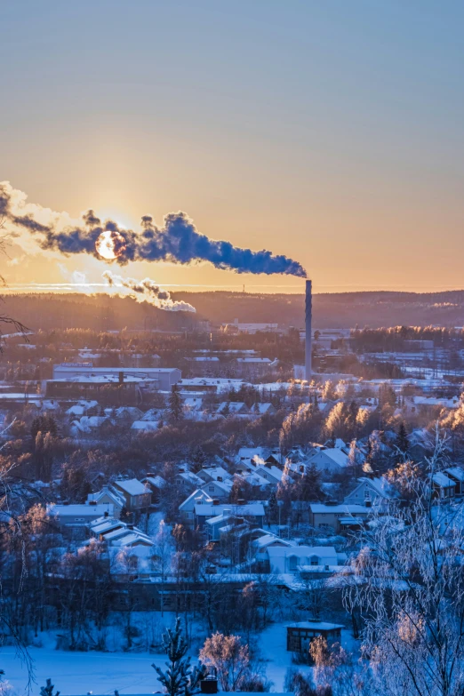 a factory plant smokes the sky in this wintery city view