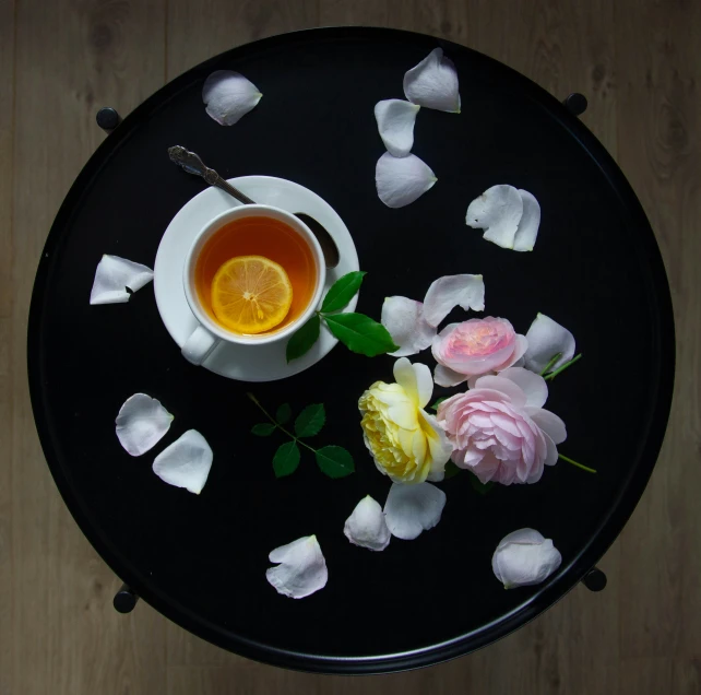 a black plate topped with white and yellow flowers