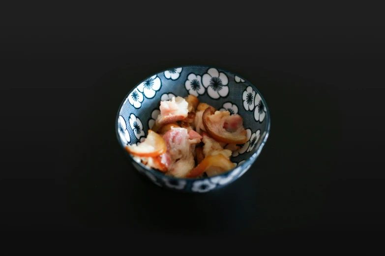 a bowl filled with some sort of food on top of a black table