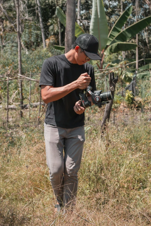 man in a black shirt holds camera and films