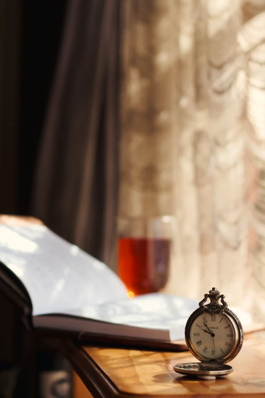 an open book and an old watch on a table