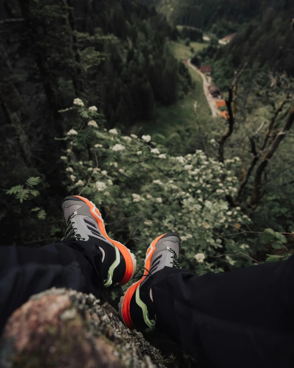 person standing on a cliff with their feet hanging up