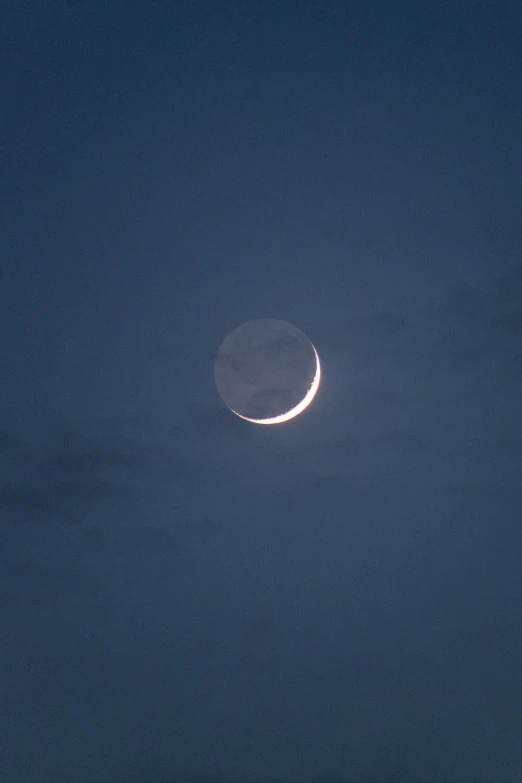 an eclipse of a crescent is seen in the sky over a large city