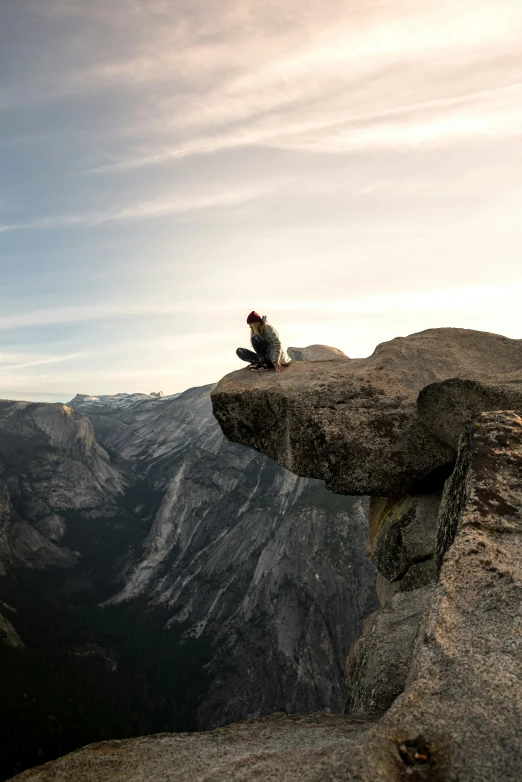 a man is sitting on top of a cliff