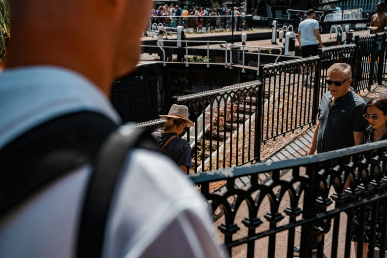 a woman is standing near a fence looking at the sky