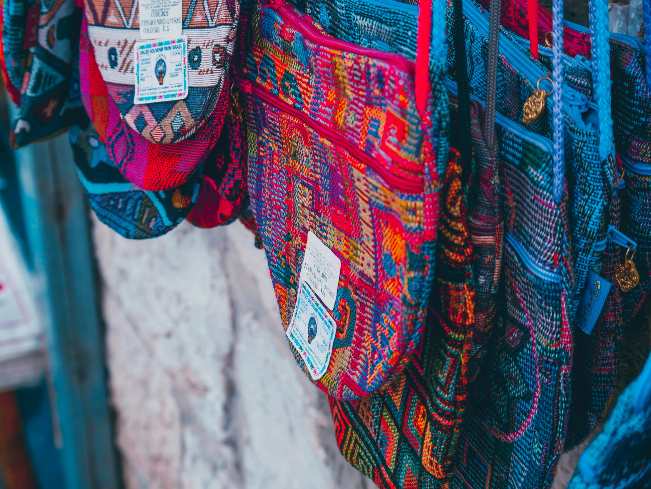 brightly colored cloths hanging on wall at outdoor market