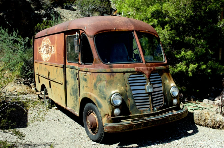 an old, rusted out van sitting in a forest