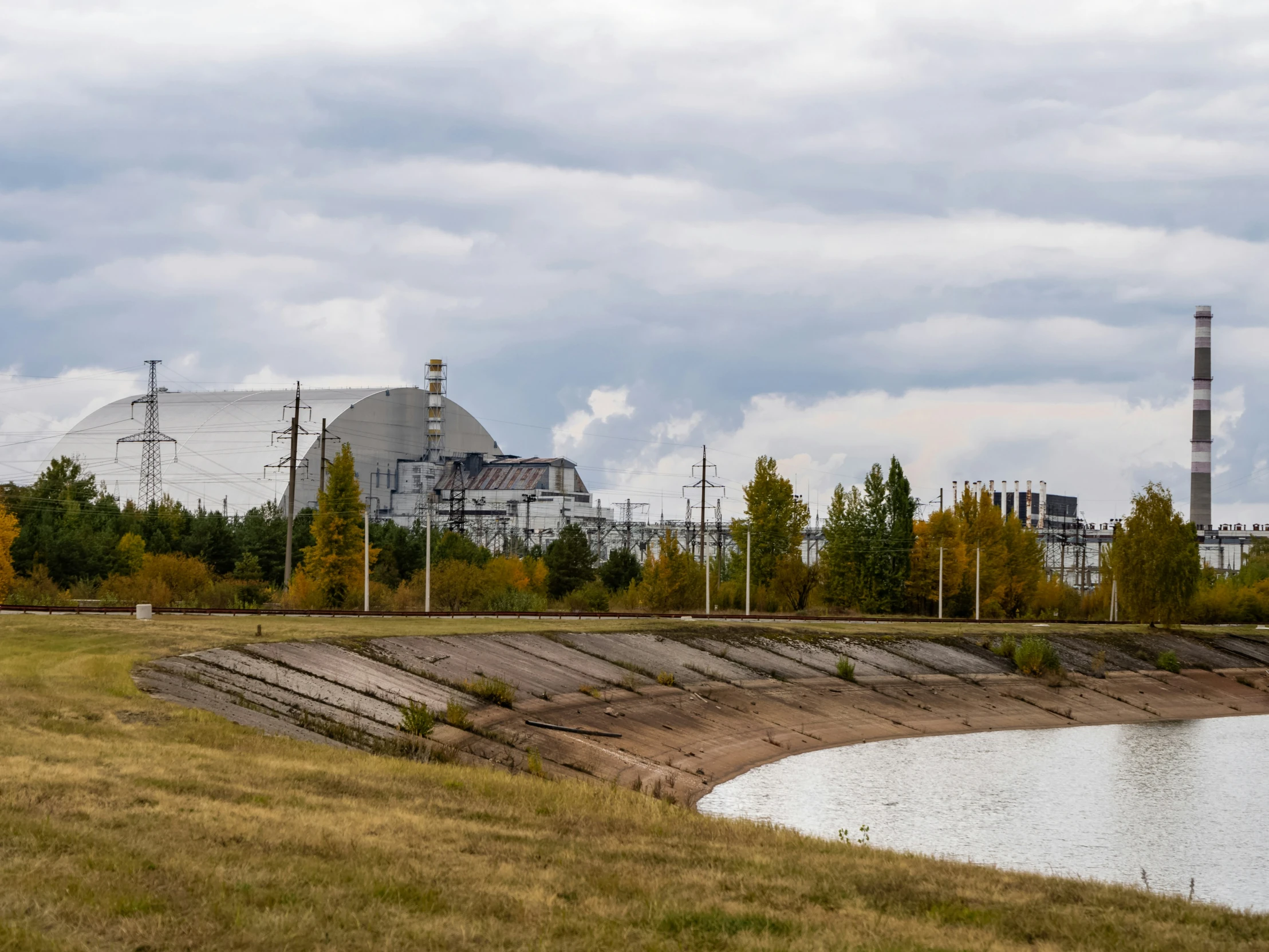 an industrial building sitting behind the water