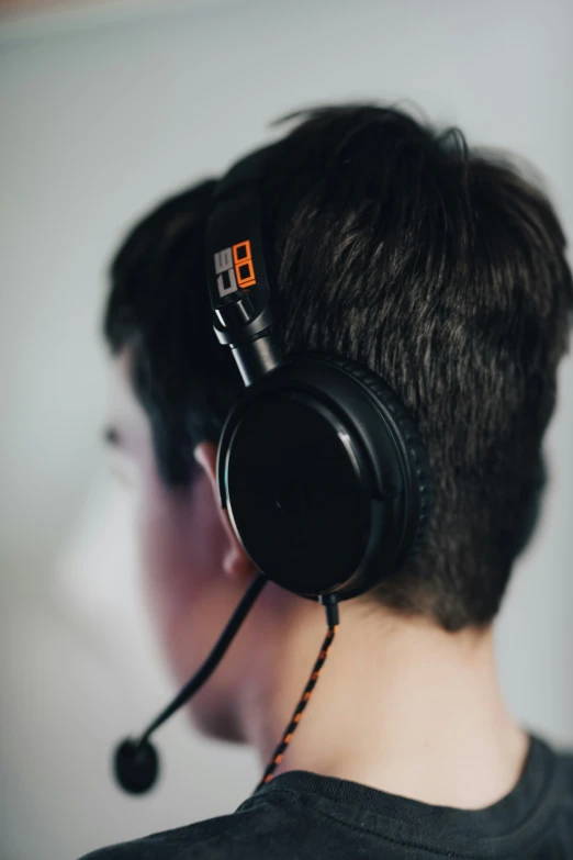 a young man with black headphones and a grey shirt