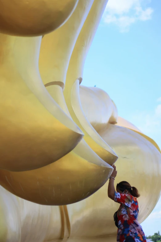 there is a woman painting a large sculpture