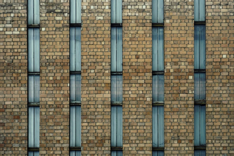 the side of a brick building that is made of thin windows