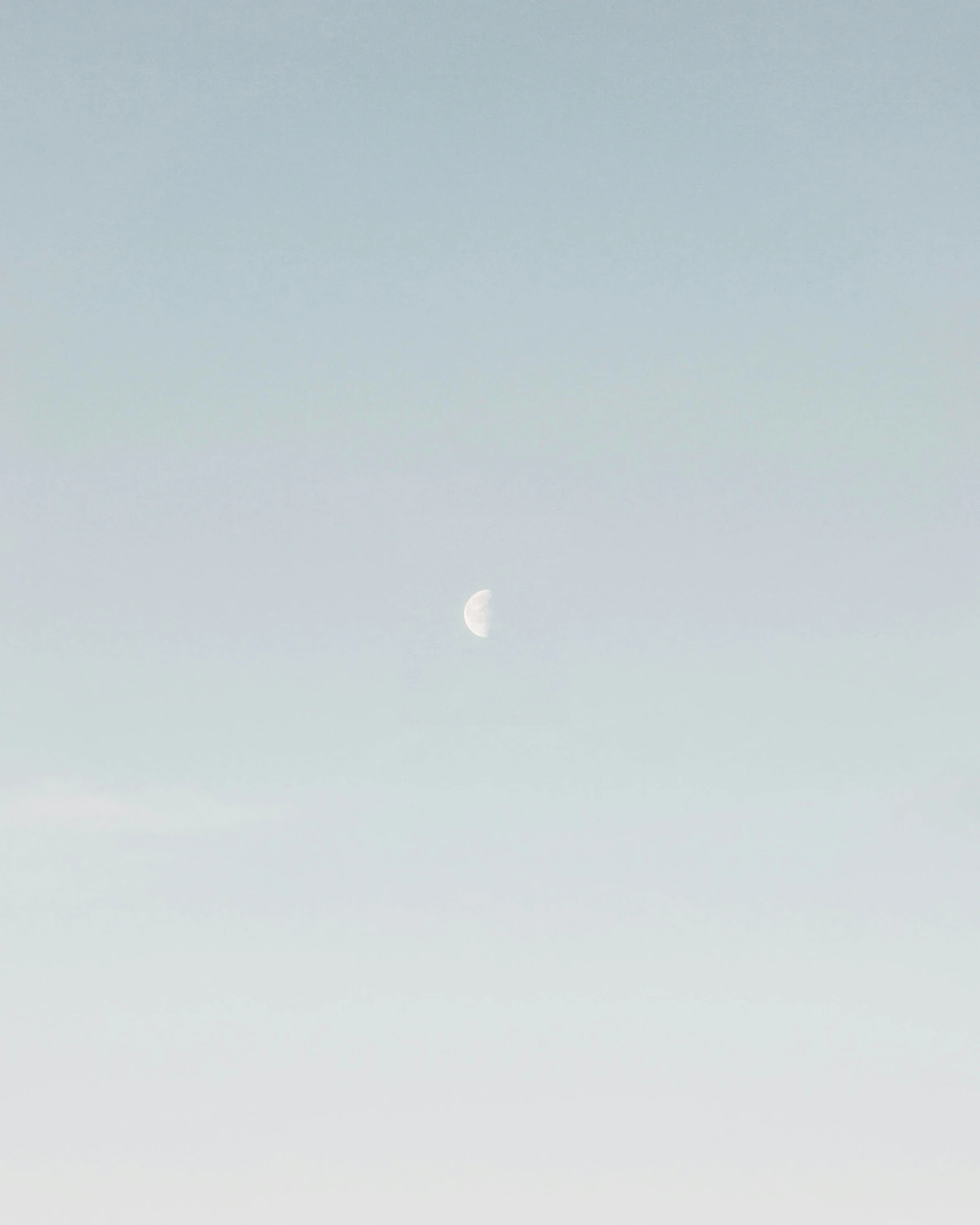 a small jetliner flying through the sky under a moon