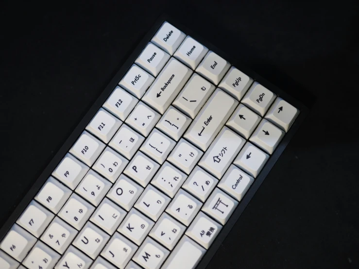 a white and black keyboard laying on top of a black surface