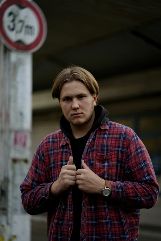 the man is standing near a no smoking sign