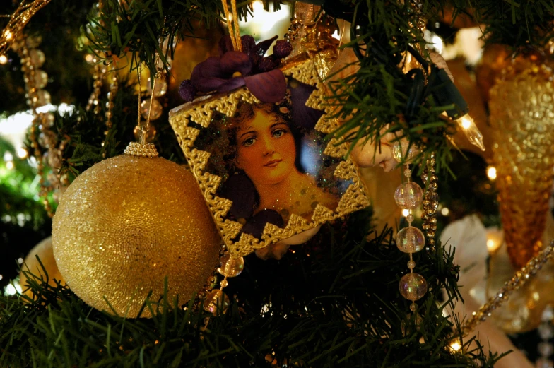 a tree with christmas ornaments and gold baubles