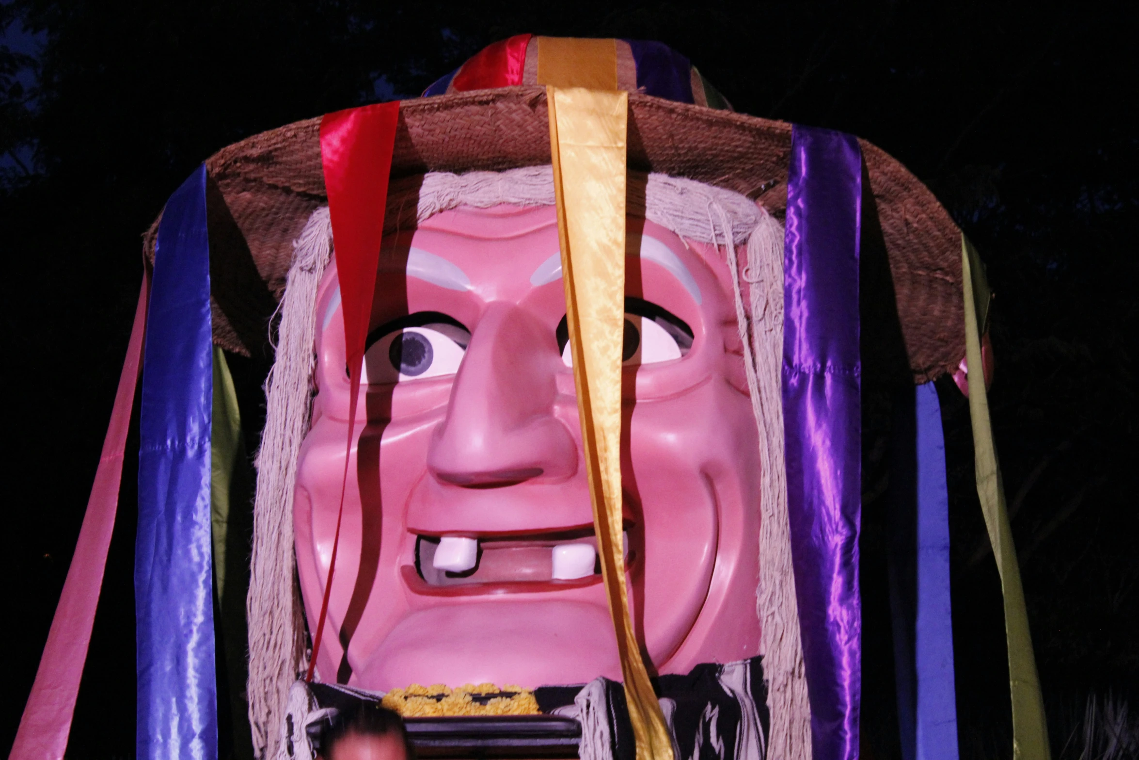 a very large face with ribbons around it