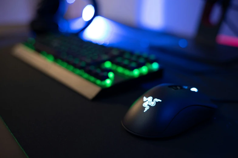 a black mouse sits on a desk with the light on