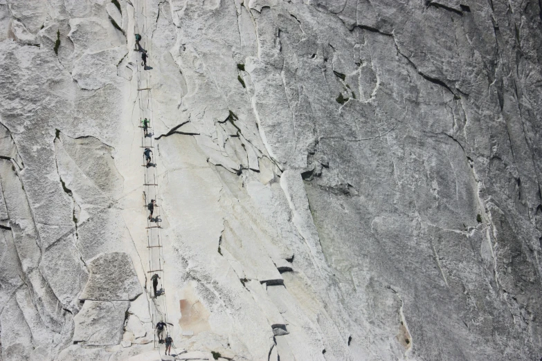 a large rock face with people climbing in it