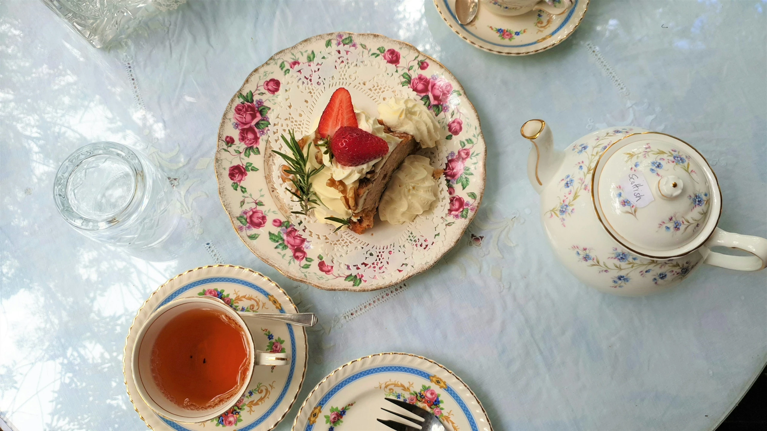 tea set with strawberries and cake on plate